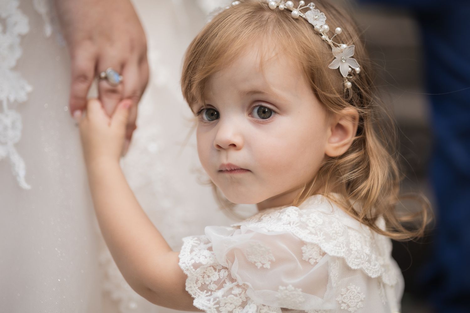 Wedding detail, flower girl holding hands with the bride outside Chelsea old town hall.