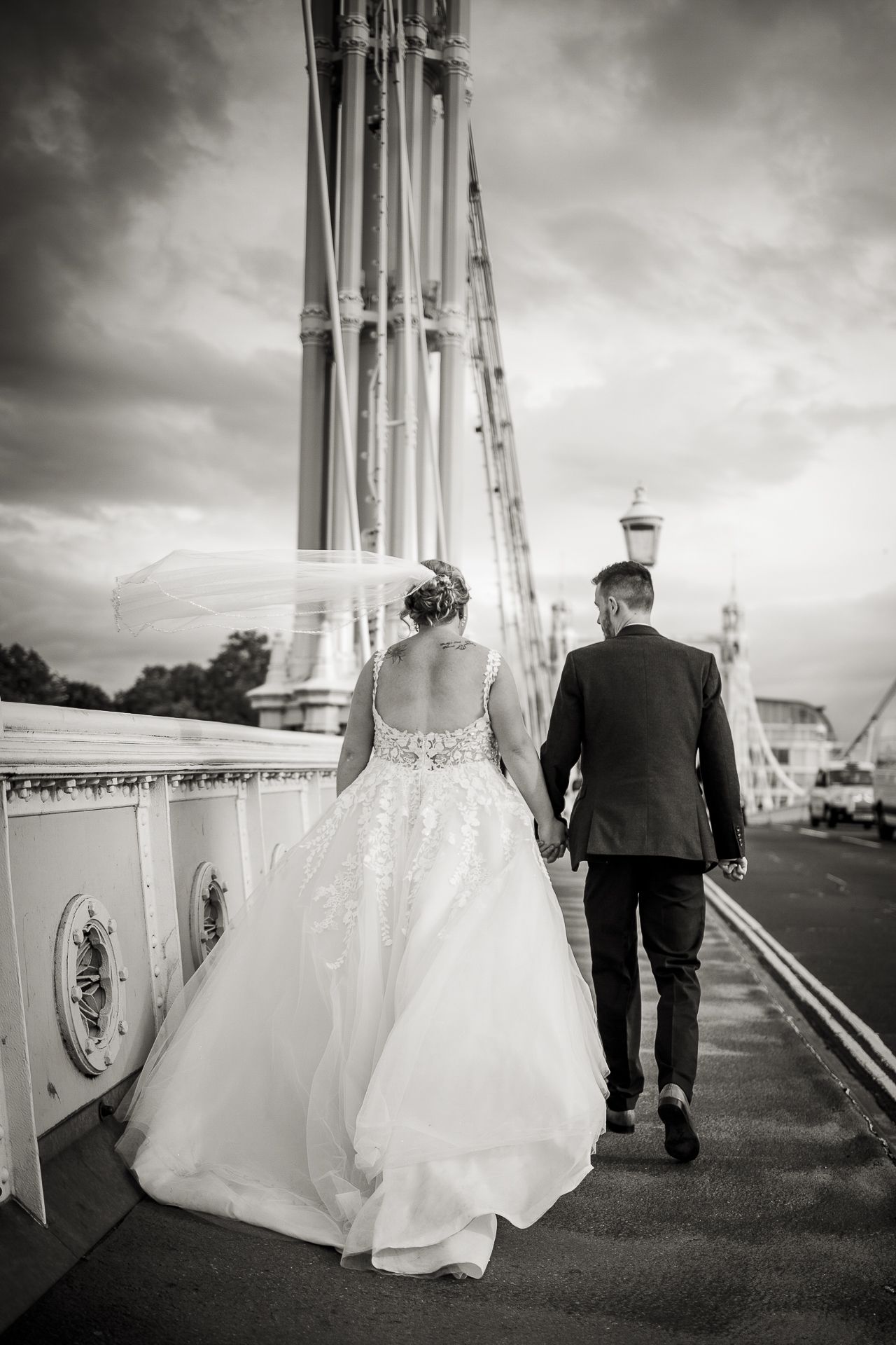 Classic Black and white photography of bride and groom walking away on Albert bridge.