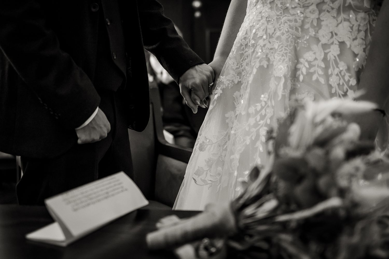Black and white fine art photo of bride and groom holding hands in Rossetti Room, Chelsea Old Town Hall, London.