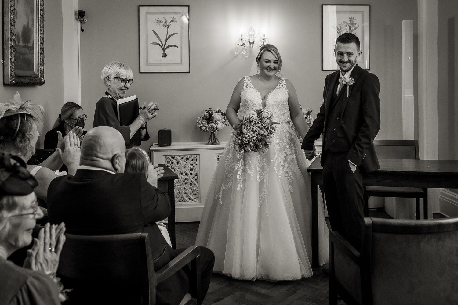 Black and white photography of bride and groom and their guests inside the Rossetti Room at Chelsea Old town hall.