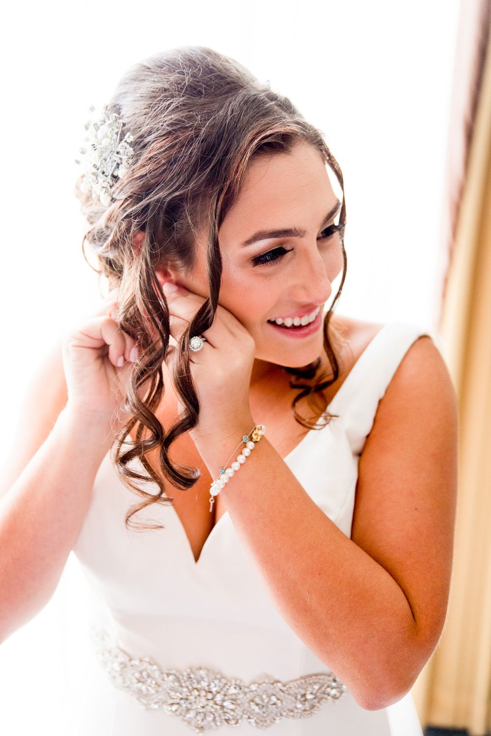 chicago bride puts on earrings and wears pearl bracelet for fall wedding in chicago