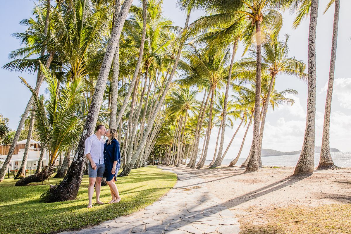Couple kissing under palm trees at Palm Cove Cairns