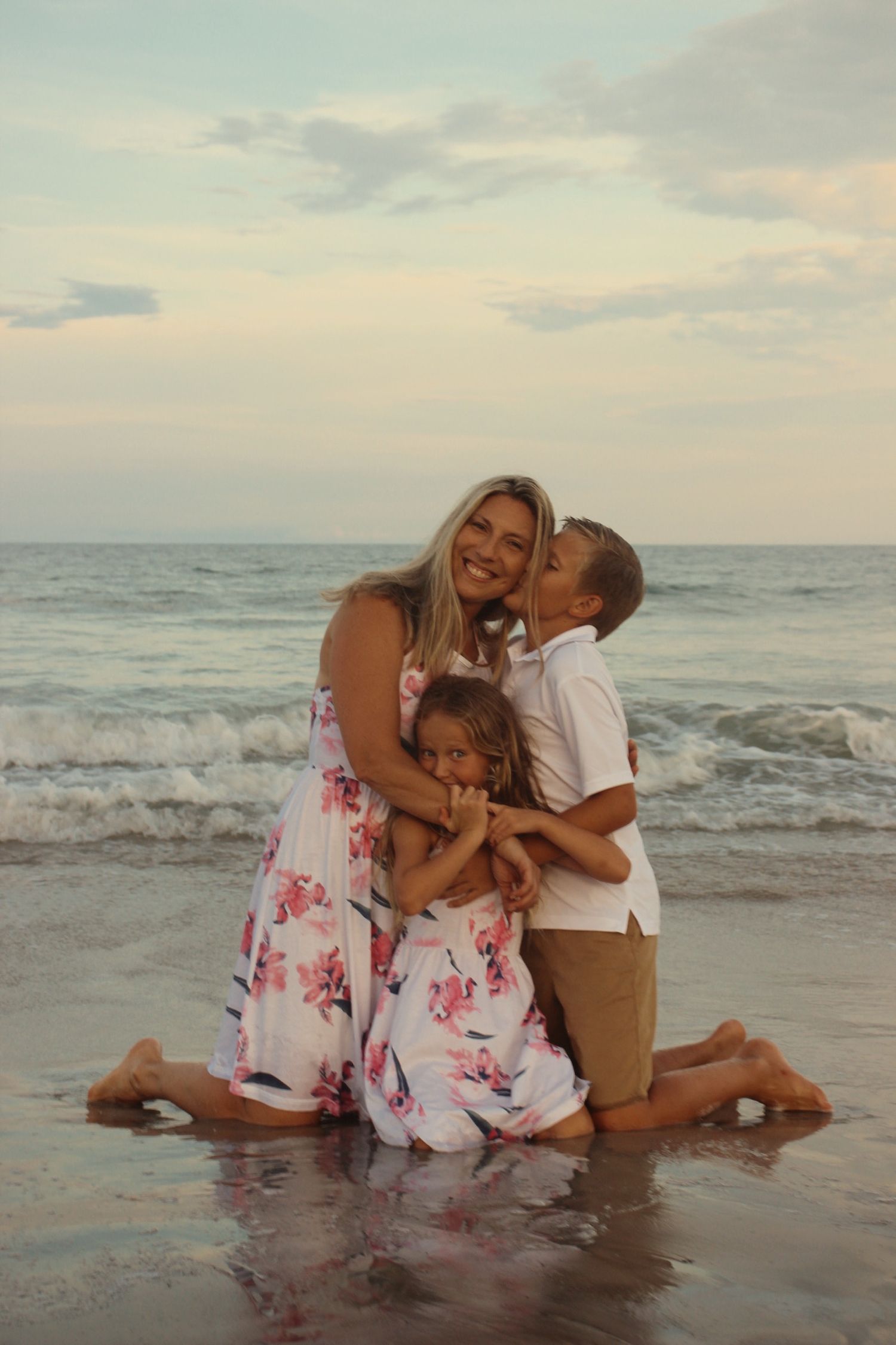 small family embracing each other on the beach