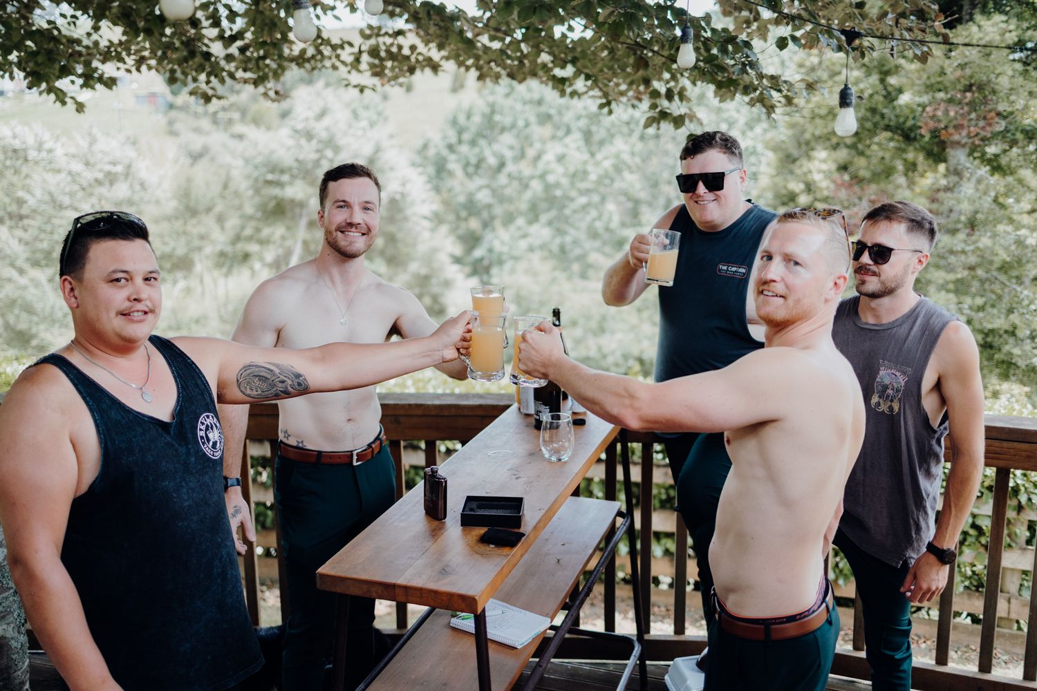 Group of friends enjoying drinks and conversation at outdoor gathering.