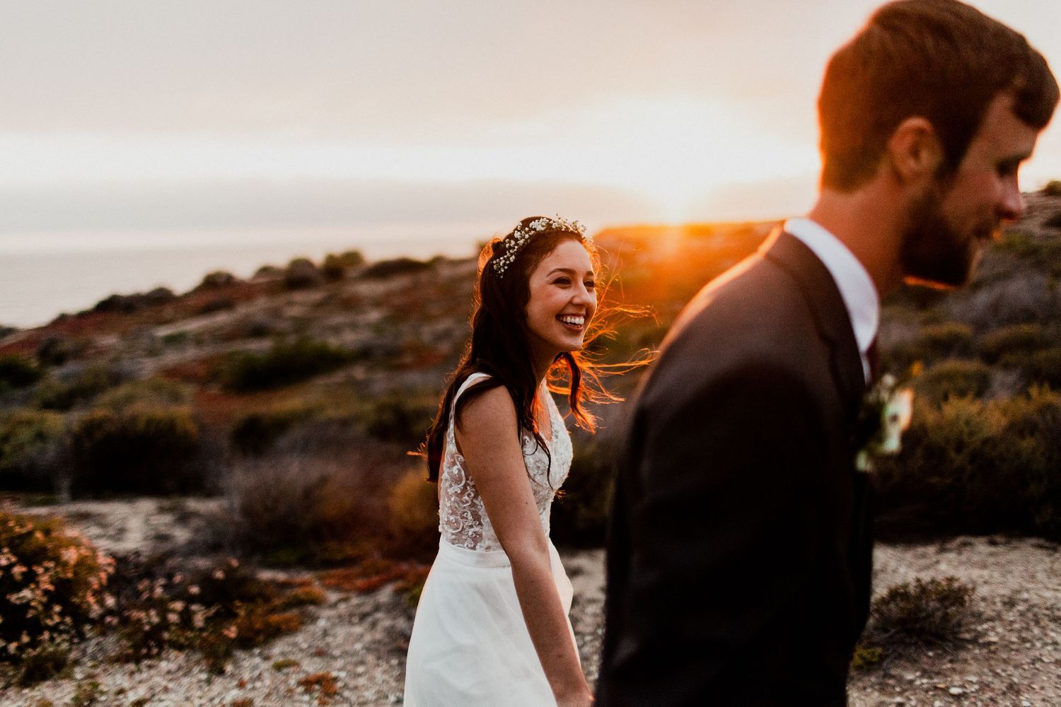 bride looking at groom while walking during golden hour