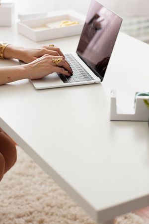 Styled stock of hands on a computer at a white desk