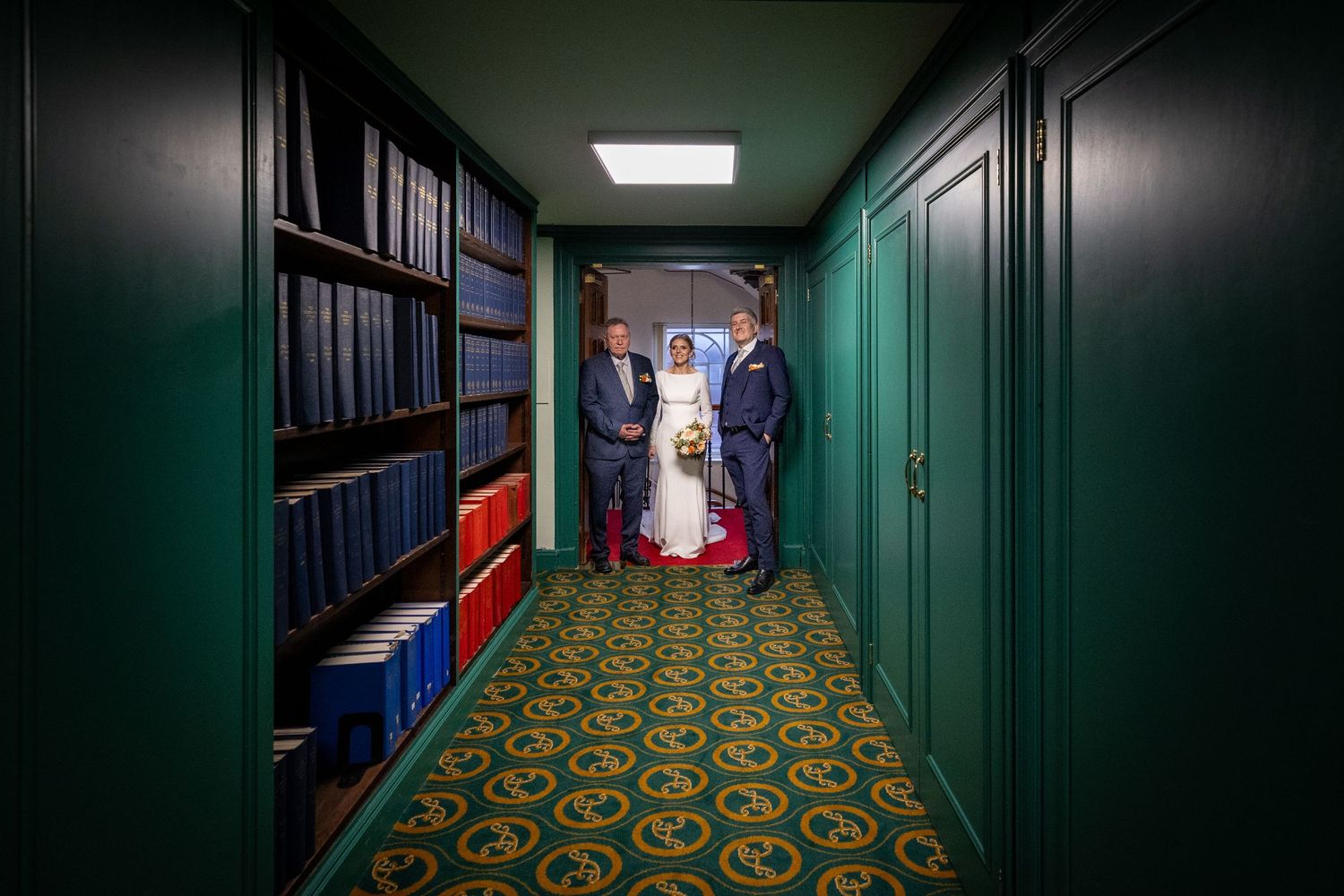 bride and groom walk through an ornate corridor in the Athenaeum. Stuart Morris Photography Liverpool wedding photographer