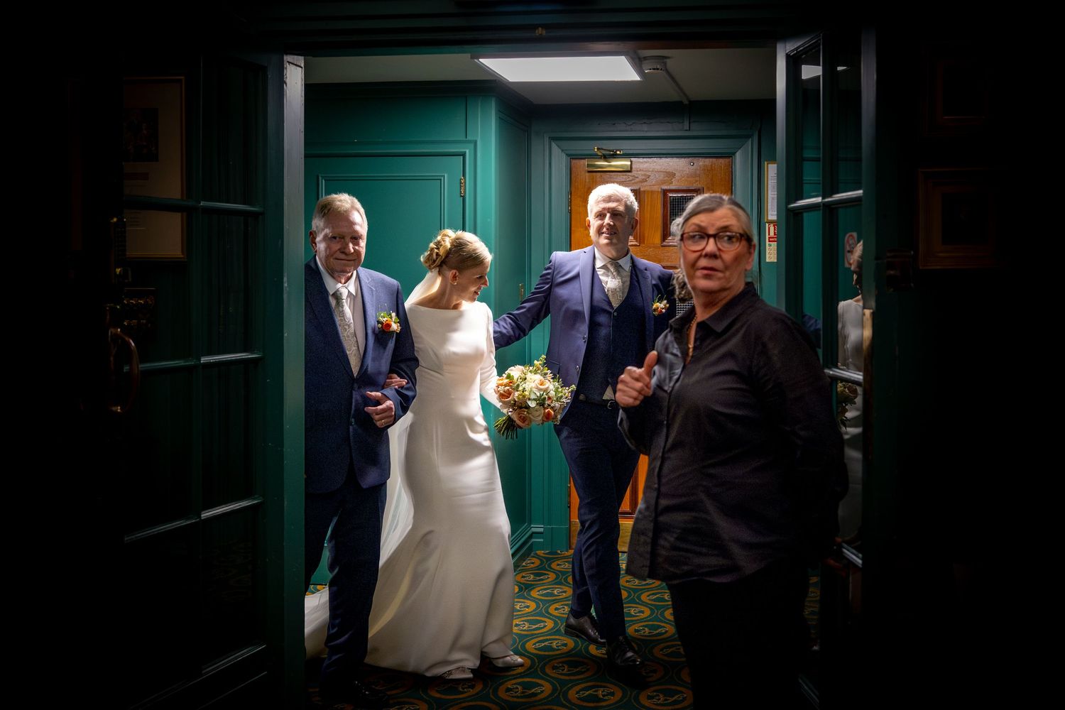 bride and groom welcomed by their wedding guests into the library at the Athenaeum, Liverpool wedding reception venue.