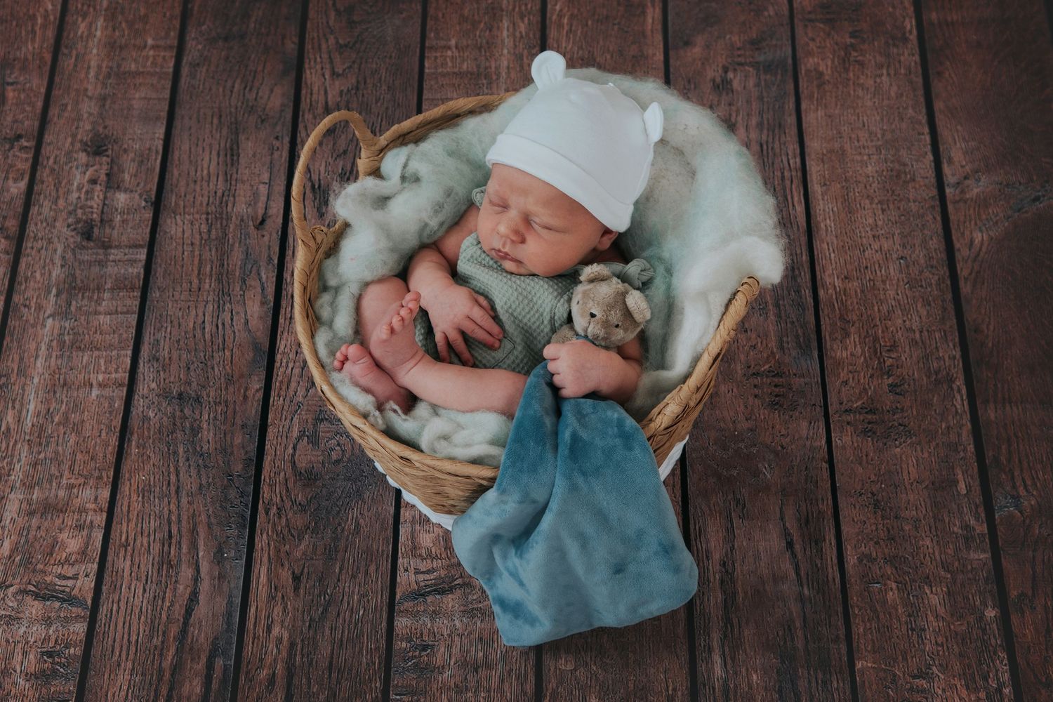 Newborn photographer in Devon, baby holding teddy in basket