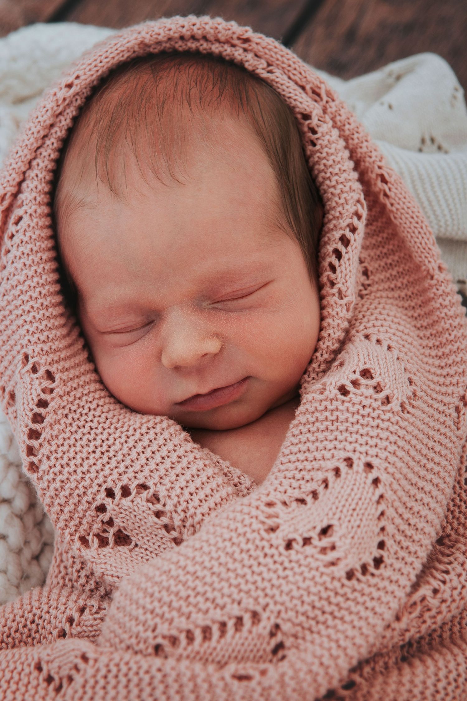 Newborn baby wrapped up in pink blacnket by devon newborn photographer Melanie Barnfield
