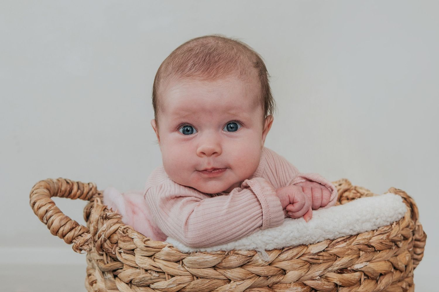 Cute baby girl in basket by devon photographer Melanie Barnfield