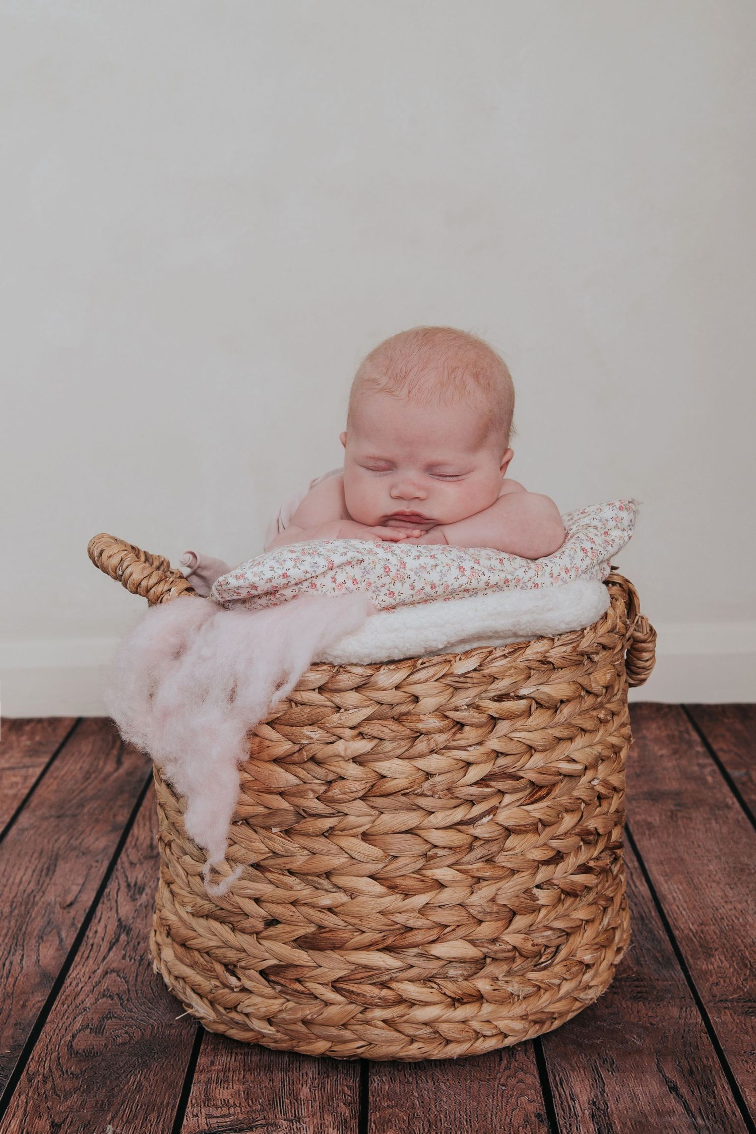 Baby girl sleeping in a basket by devon based photographer Melanie Barnfield
