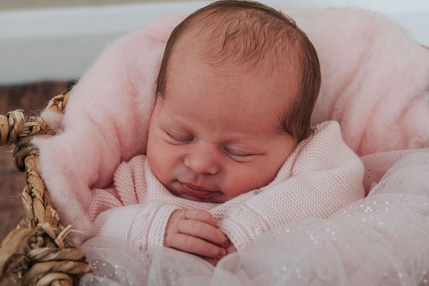 Newborn baby in pinks with a cute smile by devon based photographer Melanie Barnfield