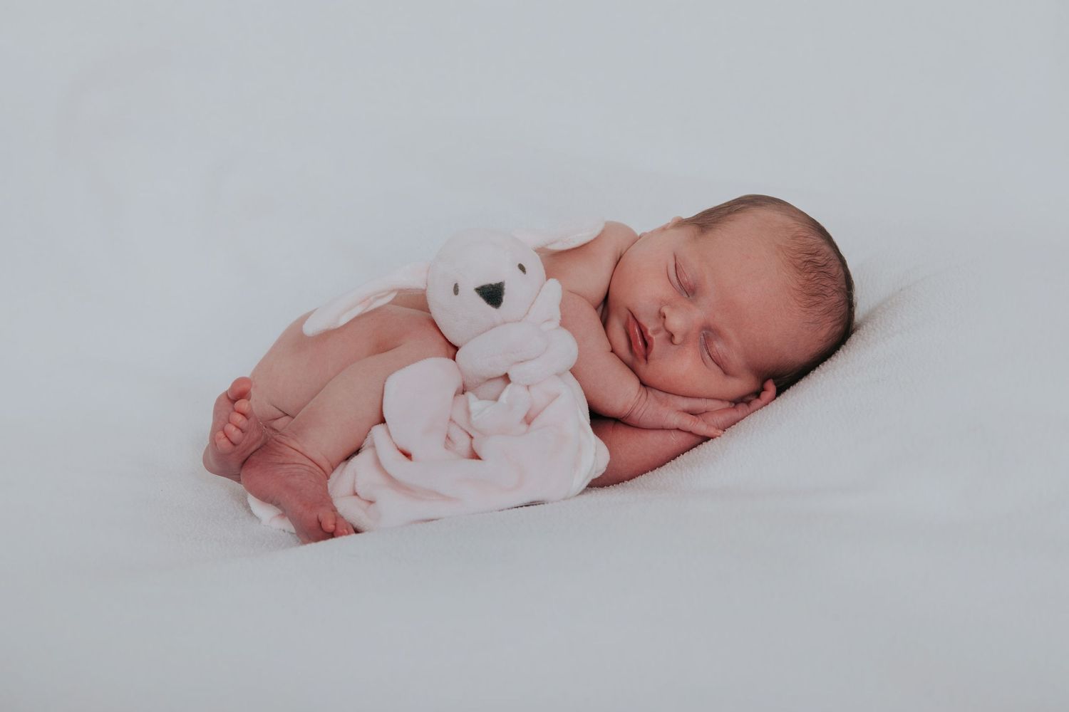 Beautiful newborn baby sleeping with teddy by newborn photographer Melanie Barnfield