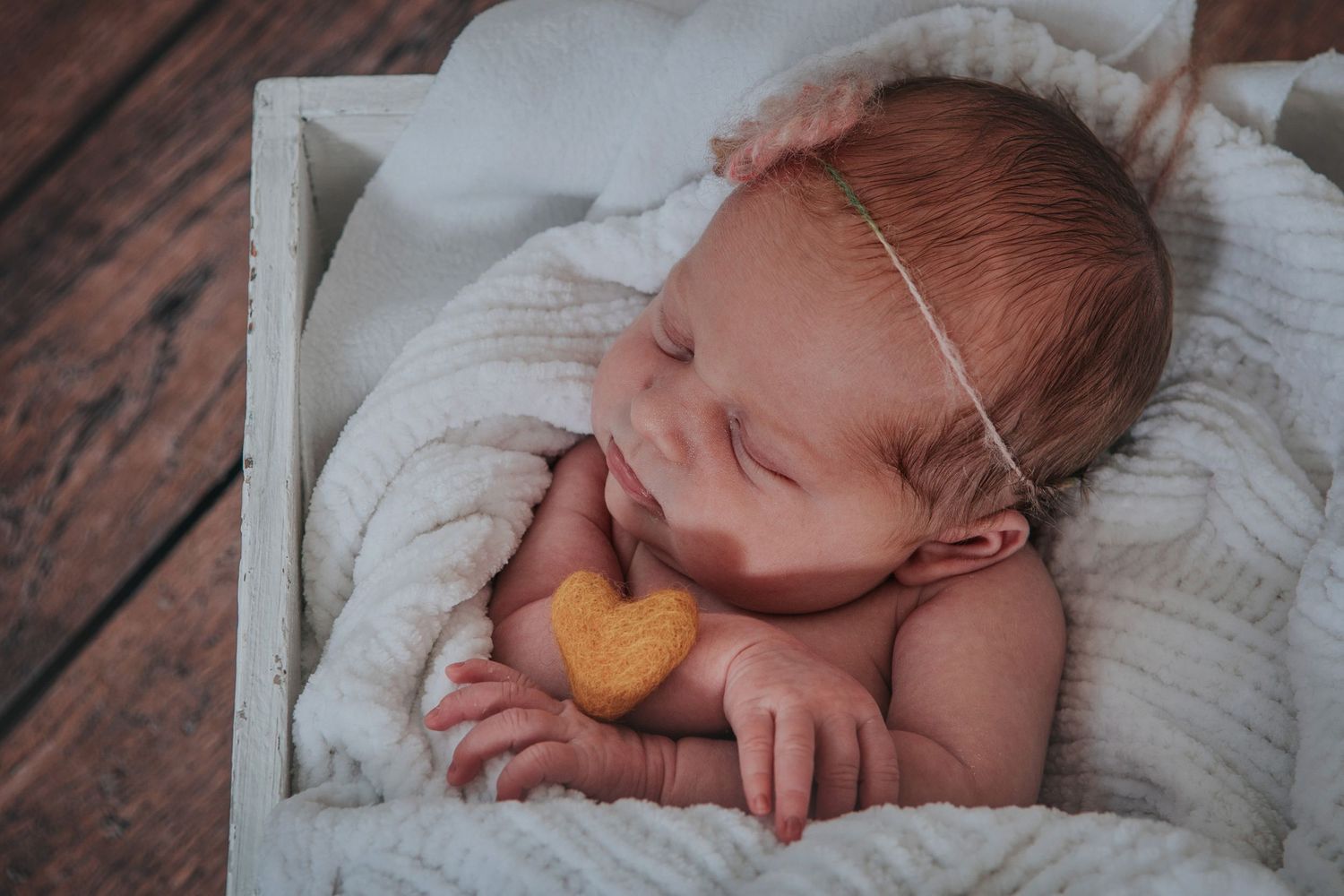 Newborn baby with heart by devon based photographer Melanie Barnfield