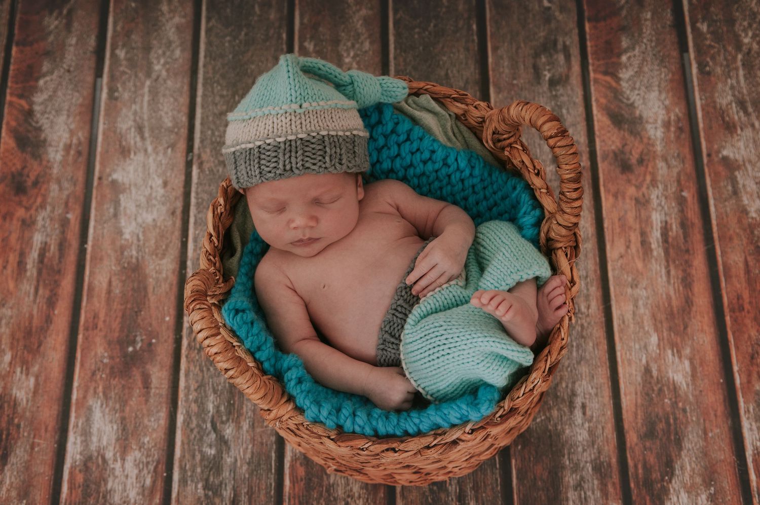 Beautiful baby boy sleeping in basket by devon based photographer Melanie Barnfield