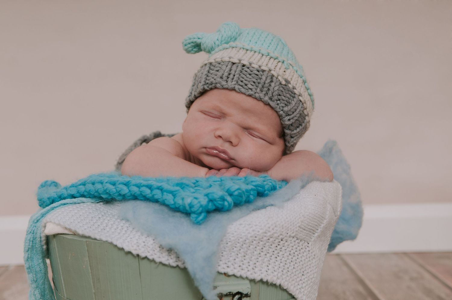 Baby boy in tub with cute woolly hat by devon based photographer Melanie Barnfield