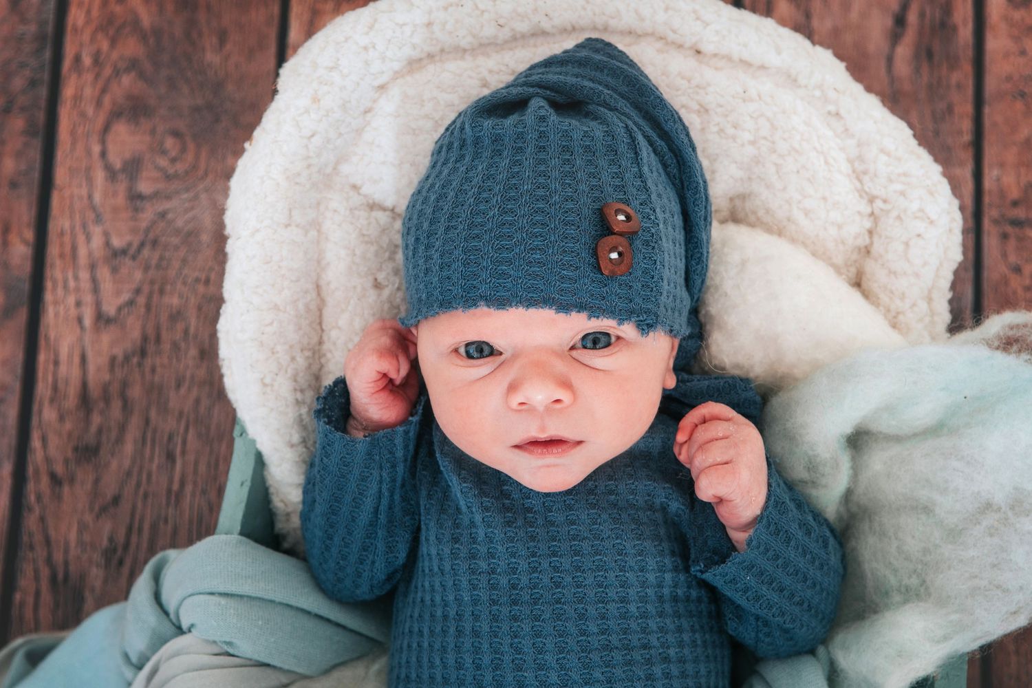Beautiful newborn portrait with gorgeous blue eyes looking into camera by devon based photographer Melanie Barnfield