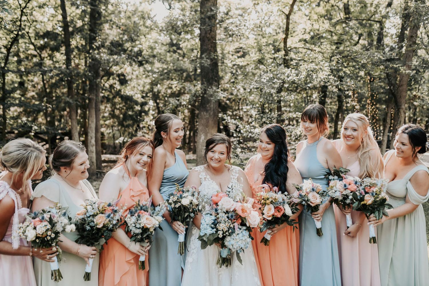 Symmetrical shot of bride centered between her girls, all in coordinated dresses