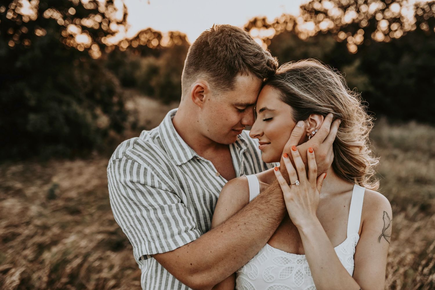Couple embracing under soft golden light during their Texas engagement shoot