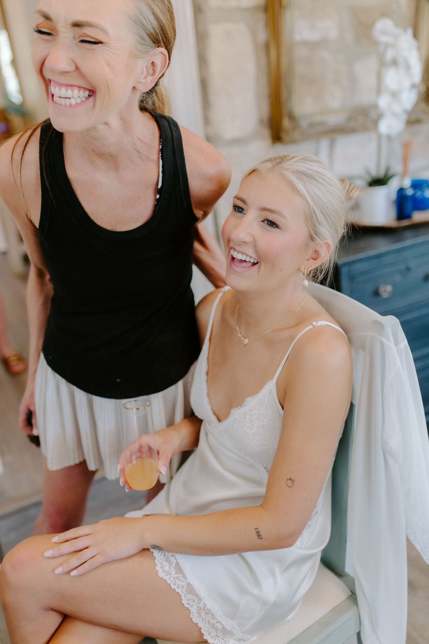 Pre-wedding preparations captured in candid moment of joy and laughter.