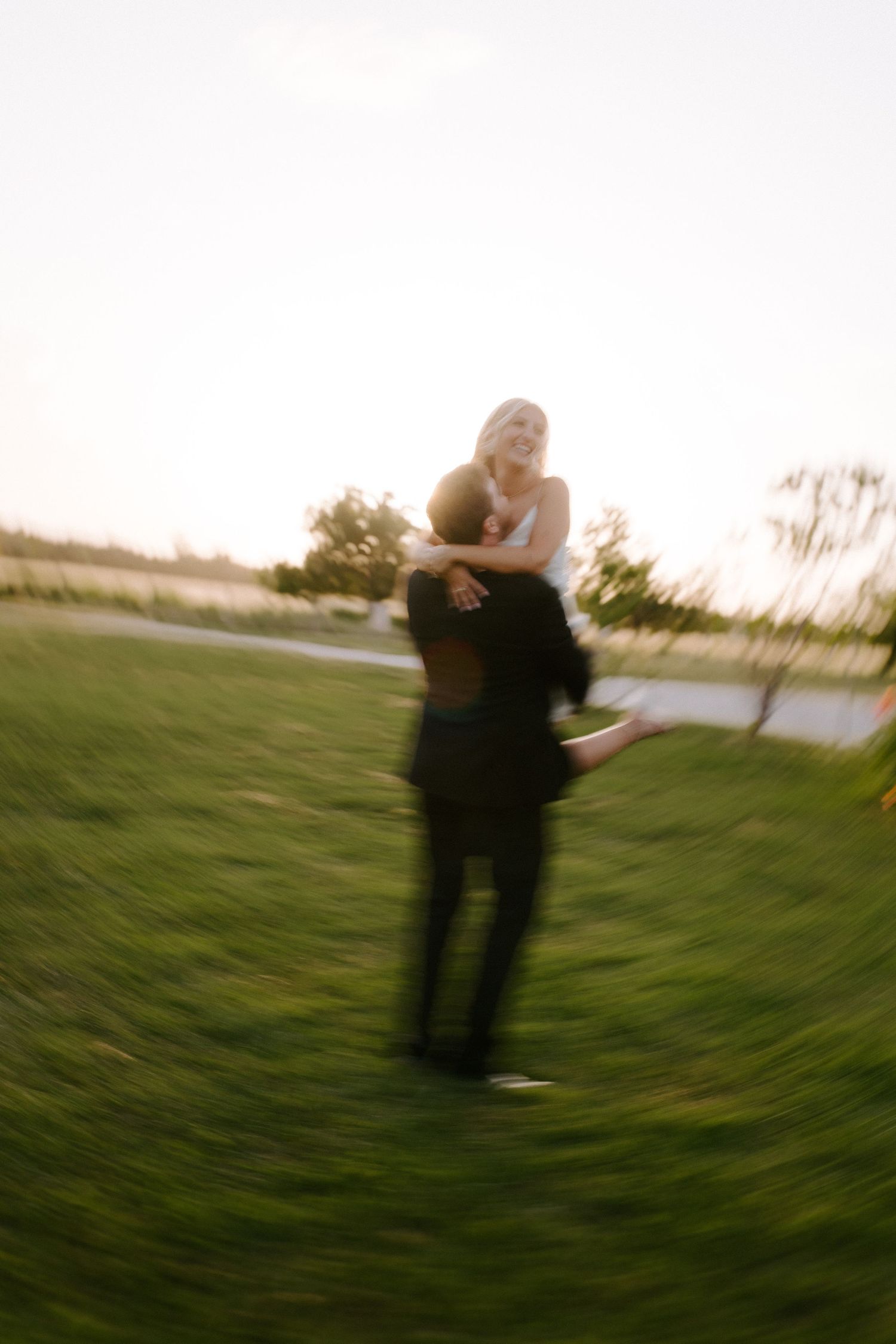 A romantic sunset moment captured in motion on a grassy field.