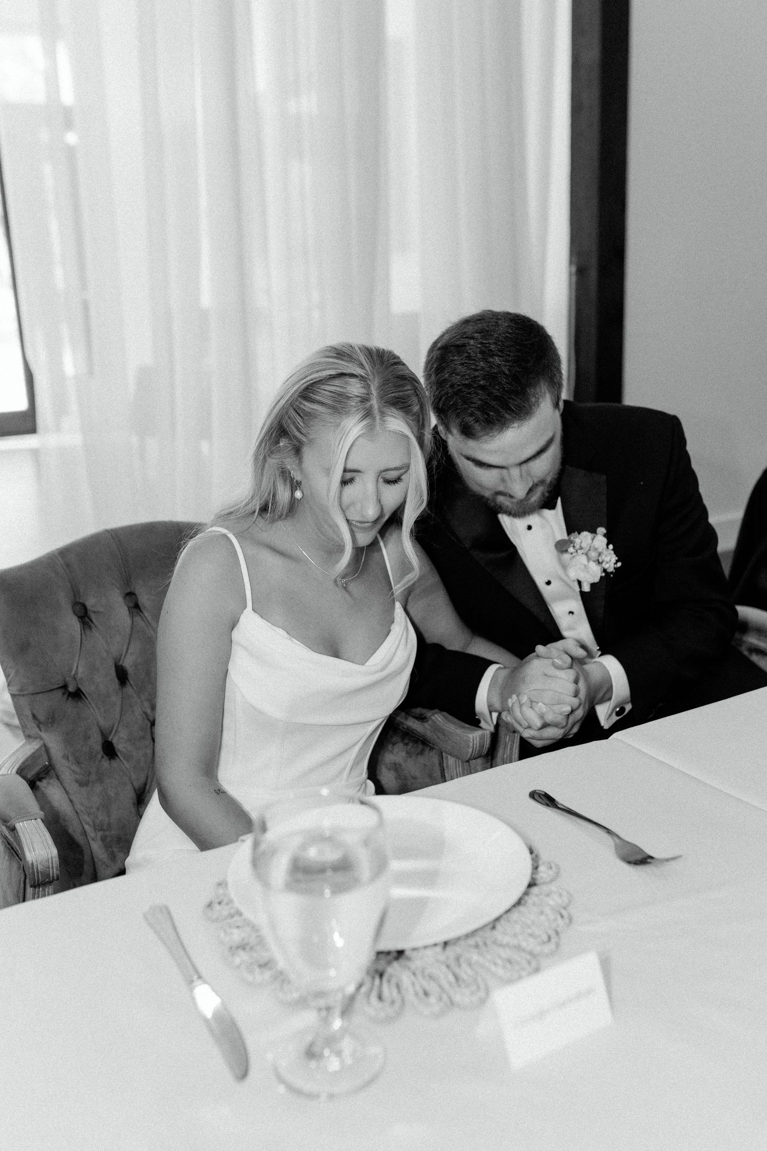 Wedding reception scene with couple signing documents at an elegant table setting.