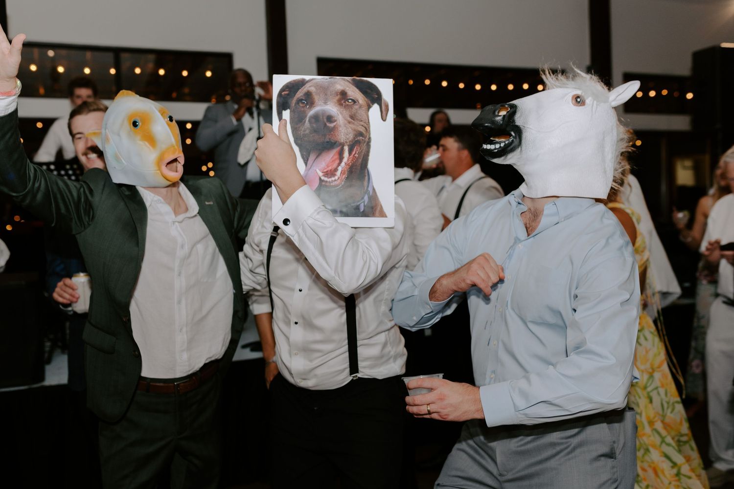 Group of party guests wearing whimsical animal masks and suspenders at a celebration event.