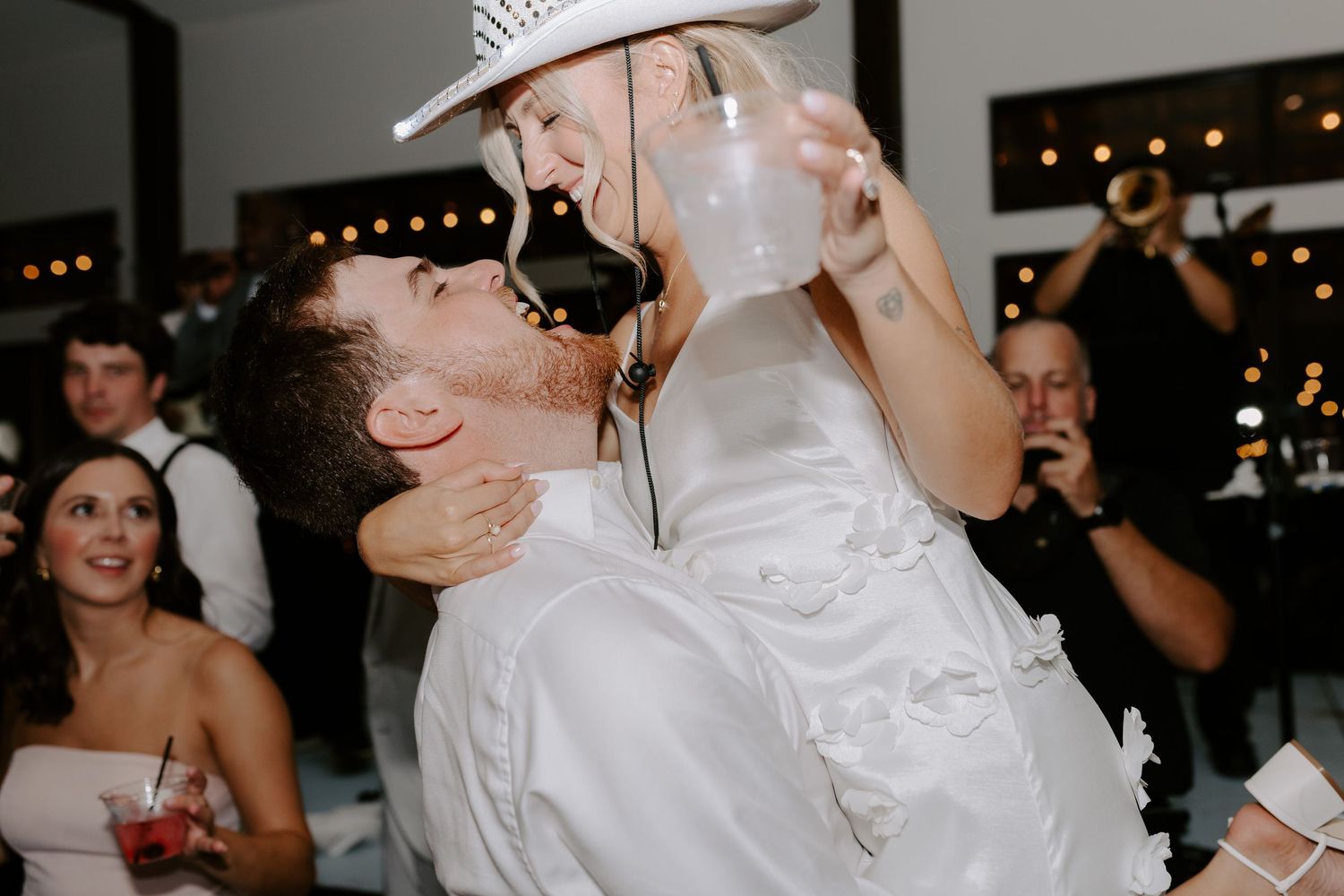 Reception celebration moment with guests cheering during a fun wedding toast.