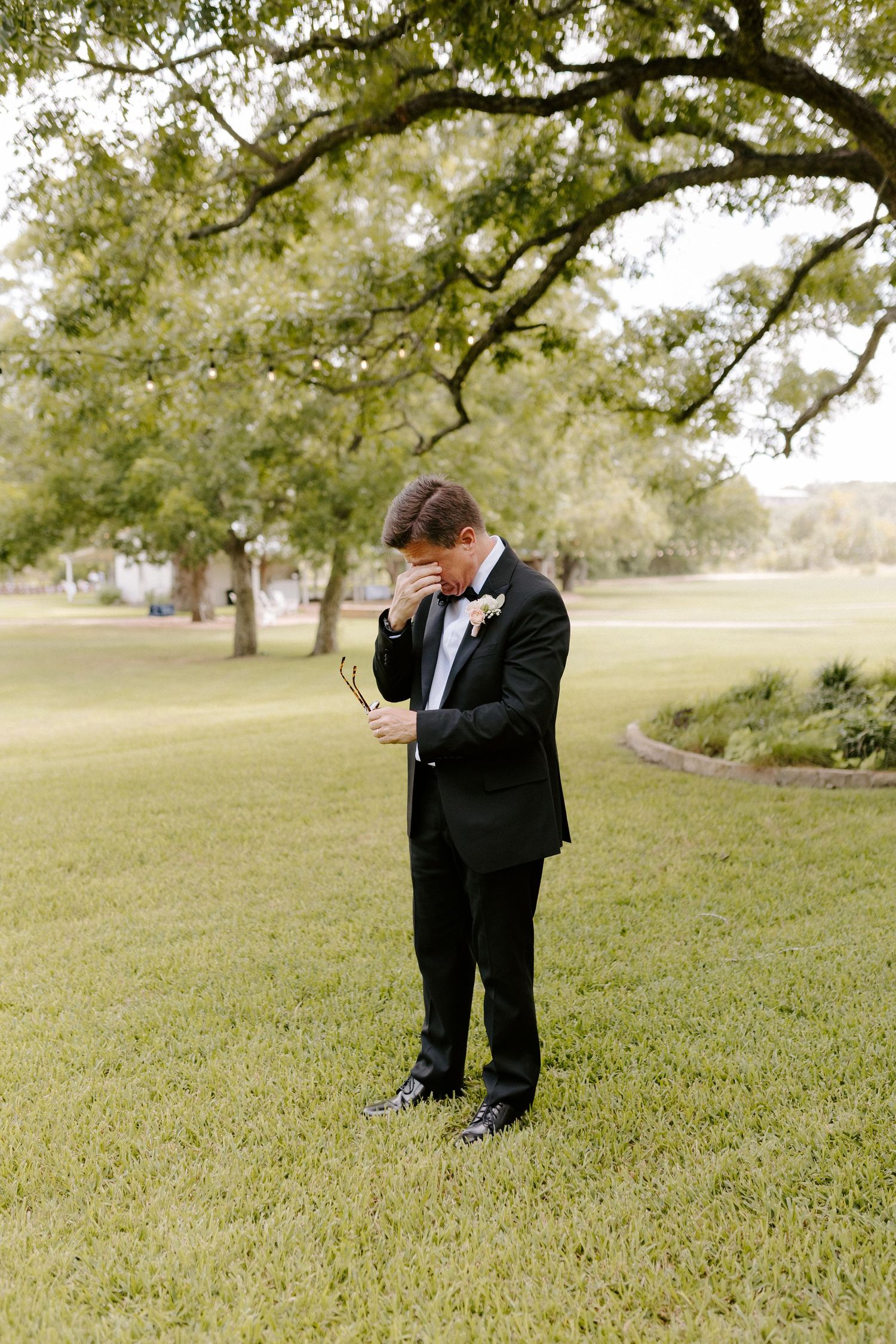 A row of emotional moments captured as a person in a black tuxedo wipes tears at an outdoor wedding ceremony.