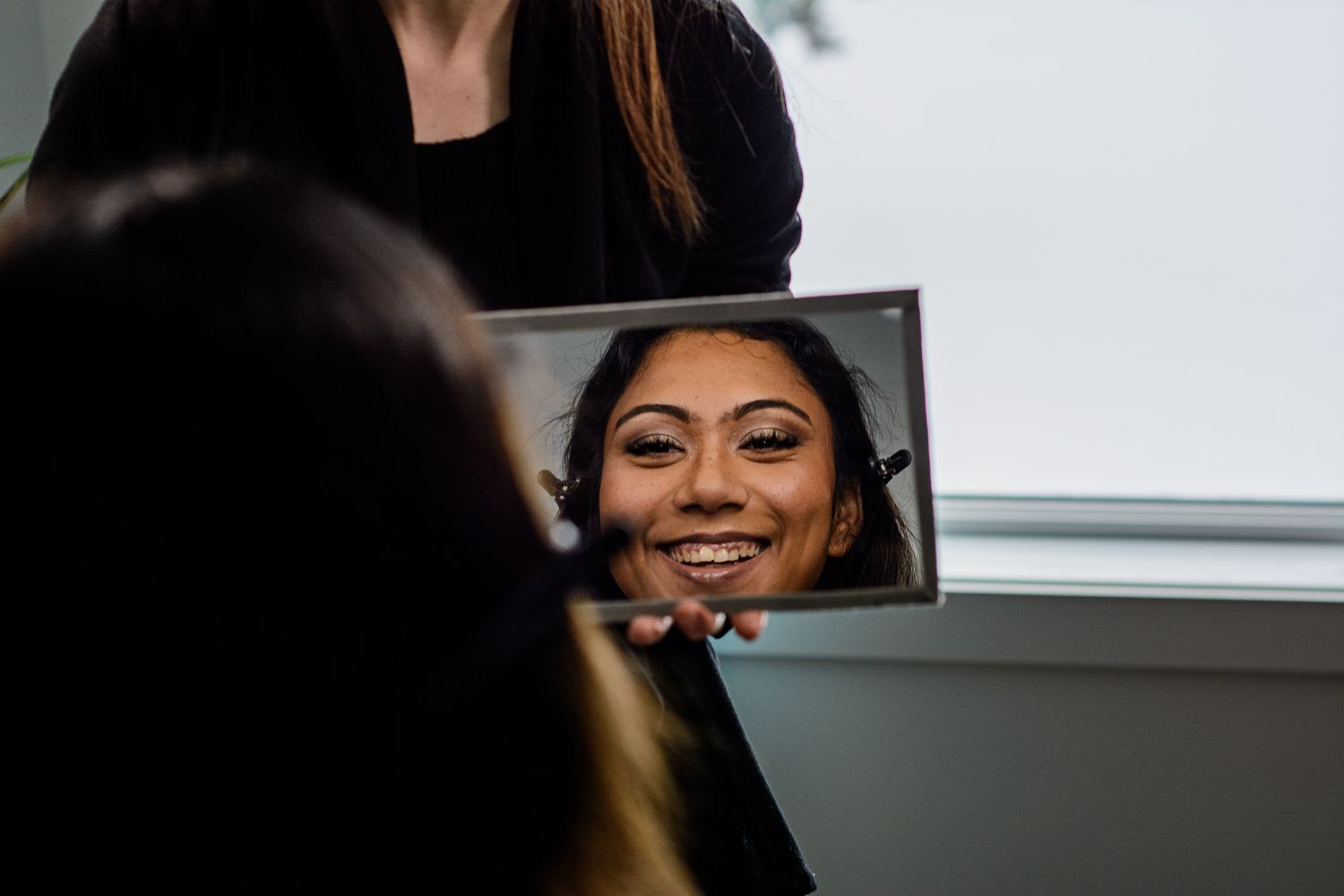 Reflection captured in handheld mirror during beauty preparation.