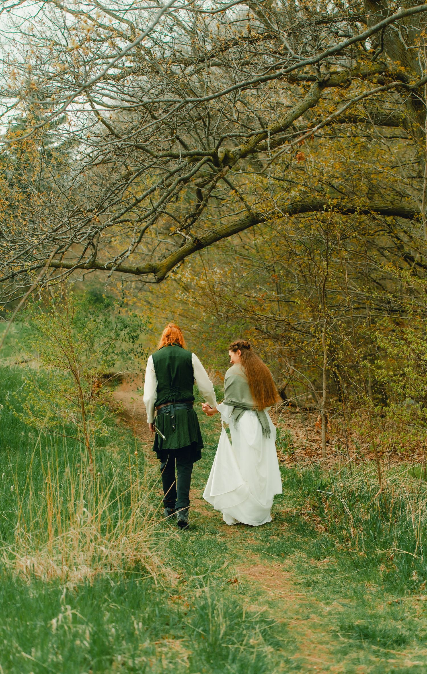 Couple walking into spring forest together.