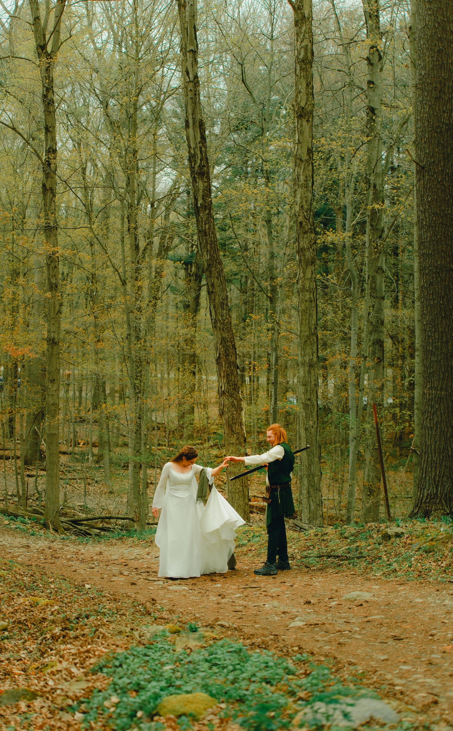 Bride and groom walking through fairytale forest together