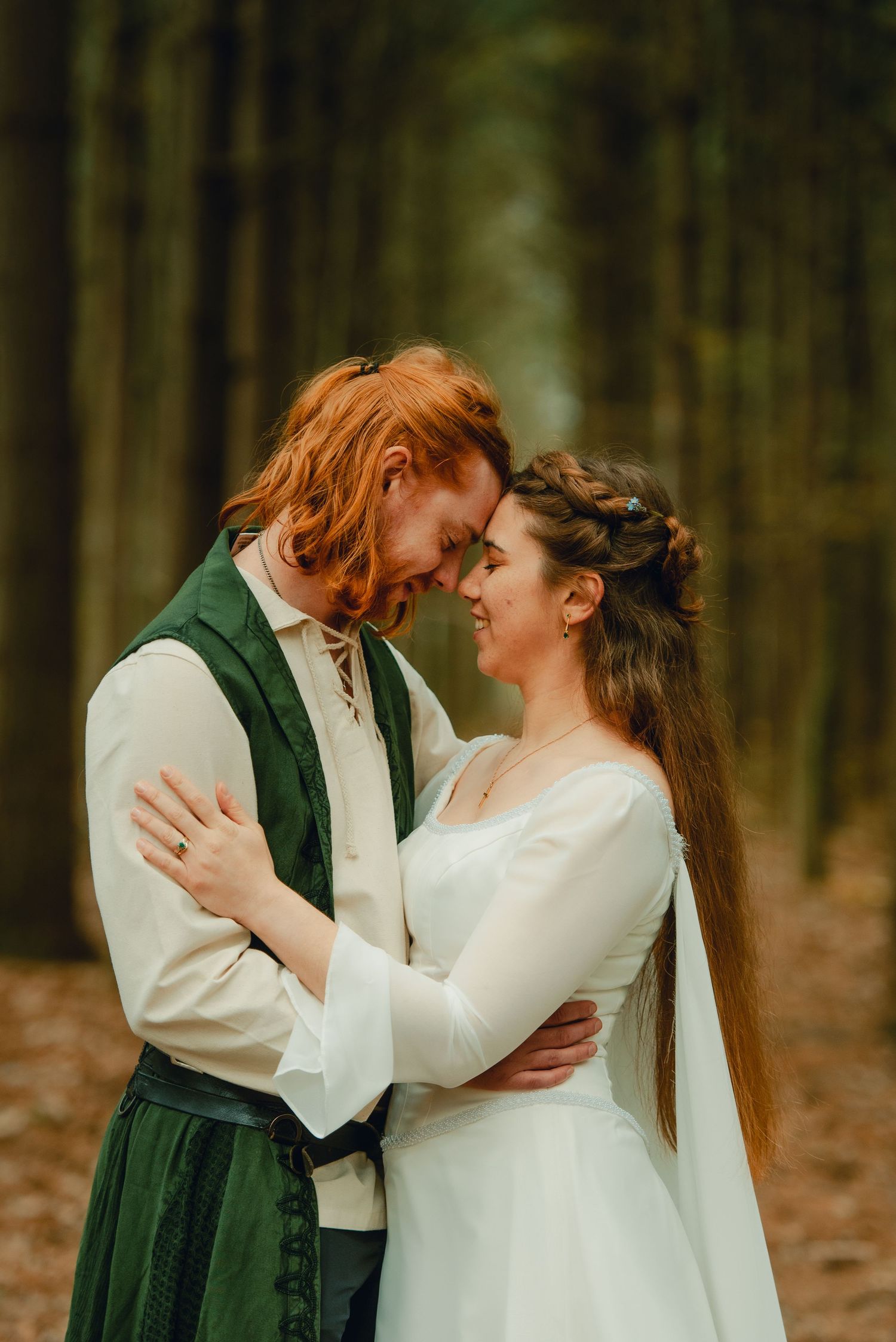 Bride and groom enjoying an intimate moment in a pine tree-lined path in the forest.