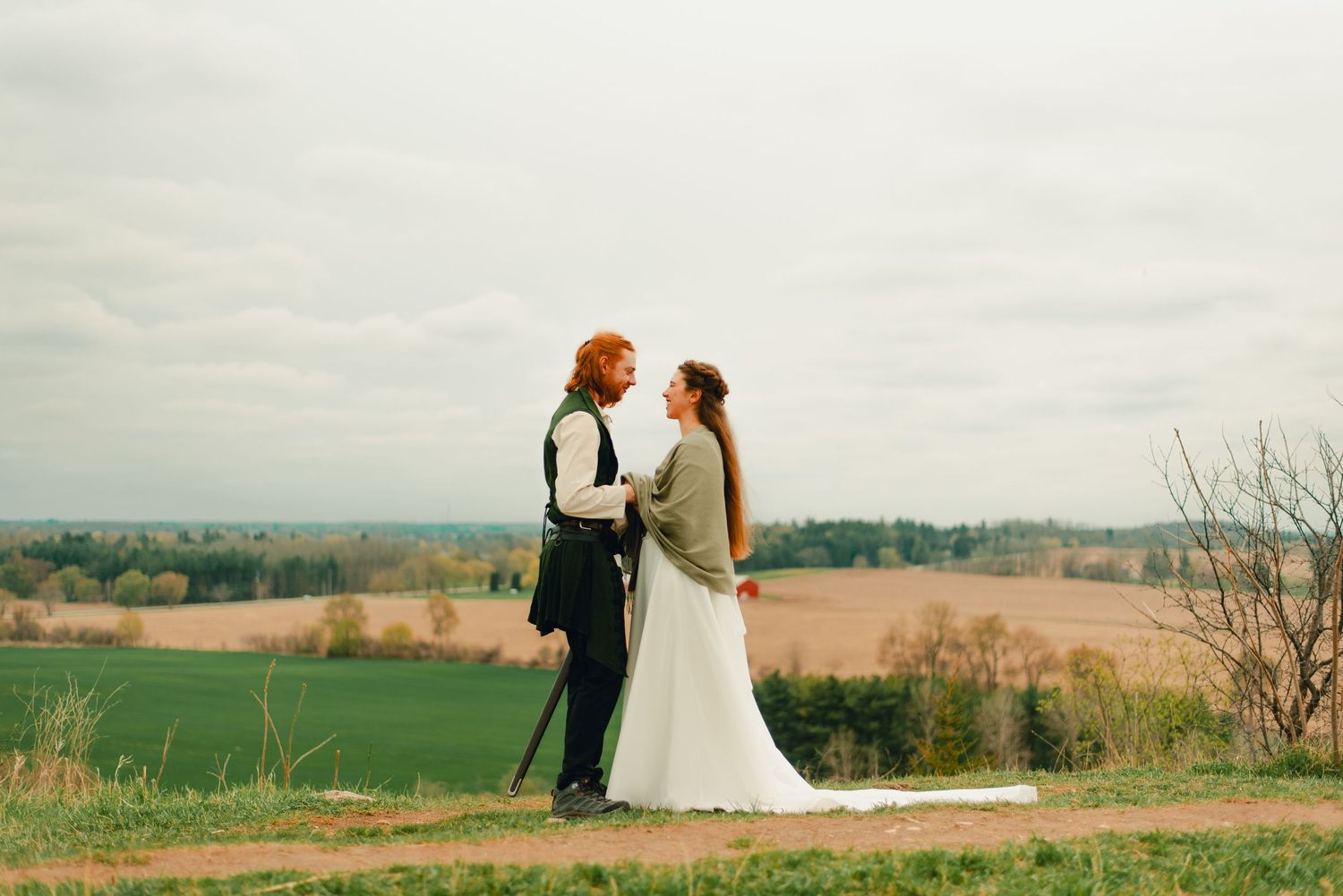 Couple embracing each other at a forest lookout point with scenic views.