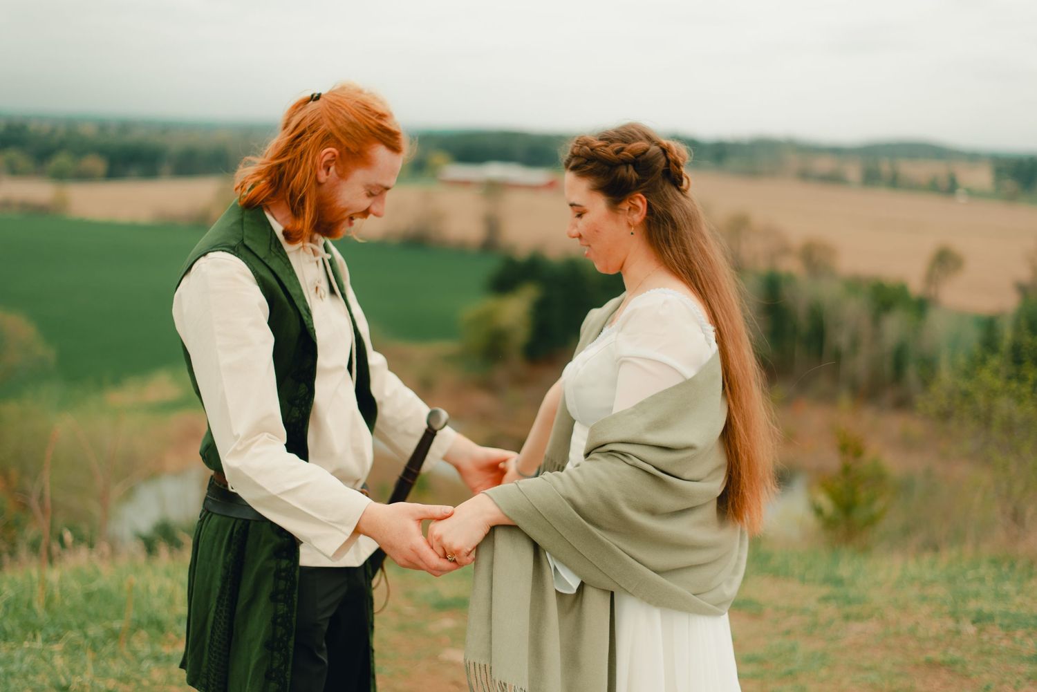 Couple embracing each other at a forest lookout point with scenic views.