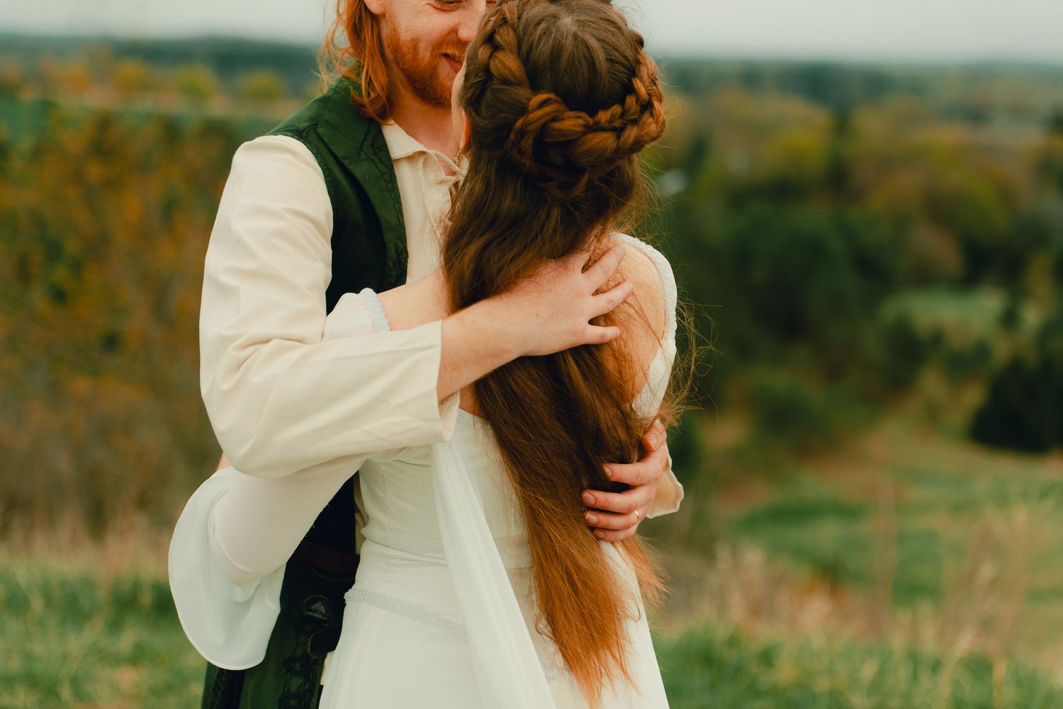 Couple embracing each other at a forest lookout point with scenic views.