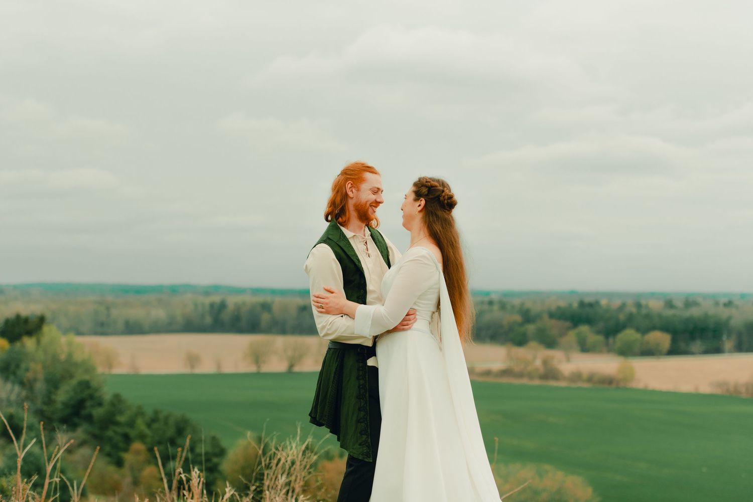 Couple embracing each other at a forest lookout point with scenic views.