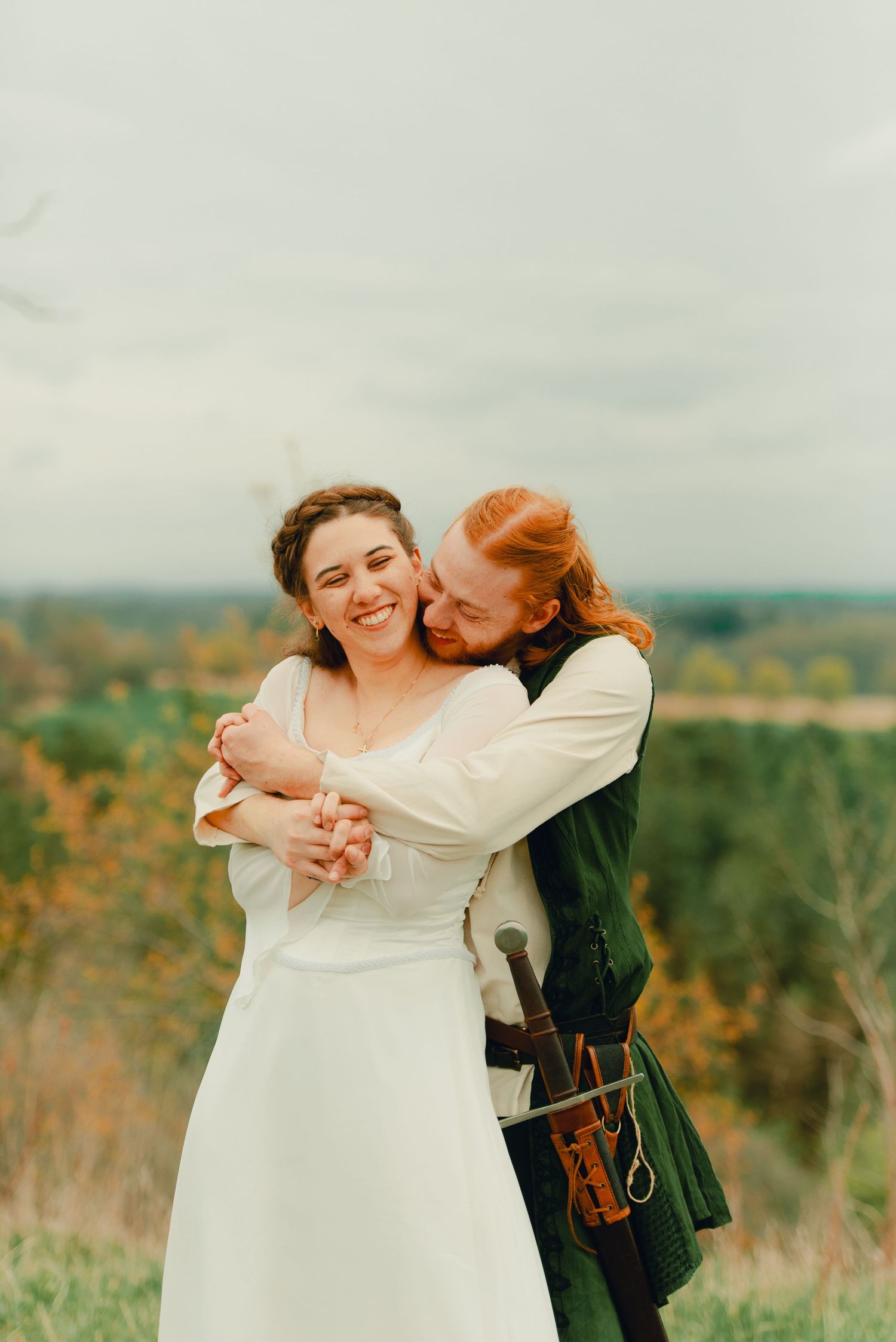 Couple embracing each other at a forest lookout point with scenic views.