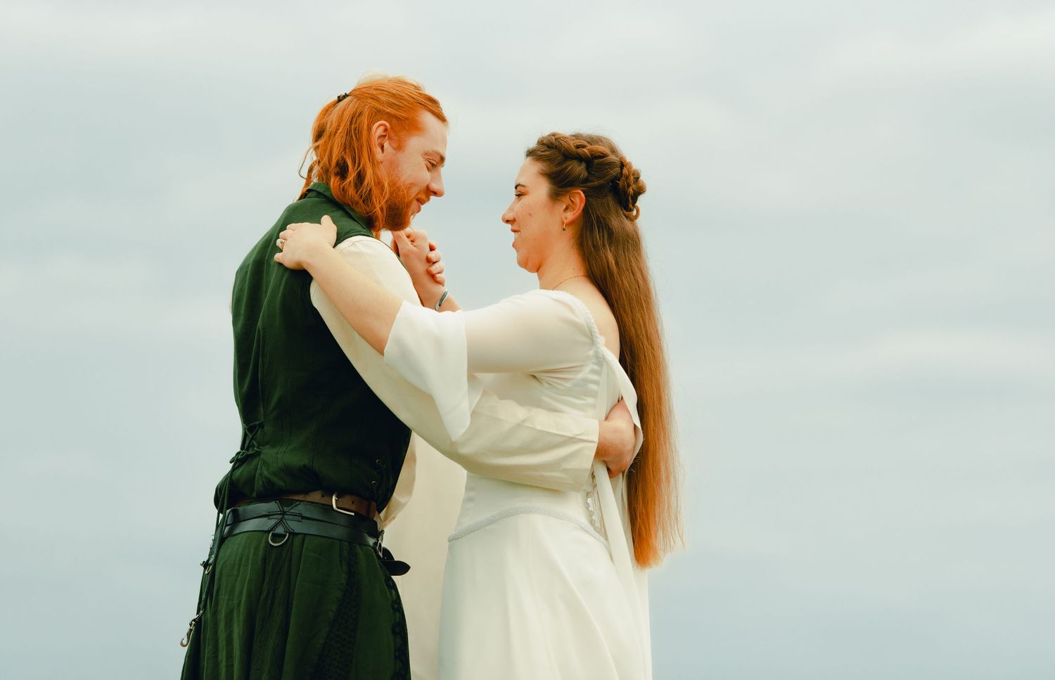 Couple embracing each other at a forest lookout point with scenic views.