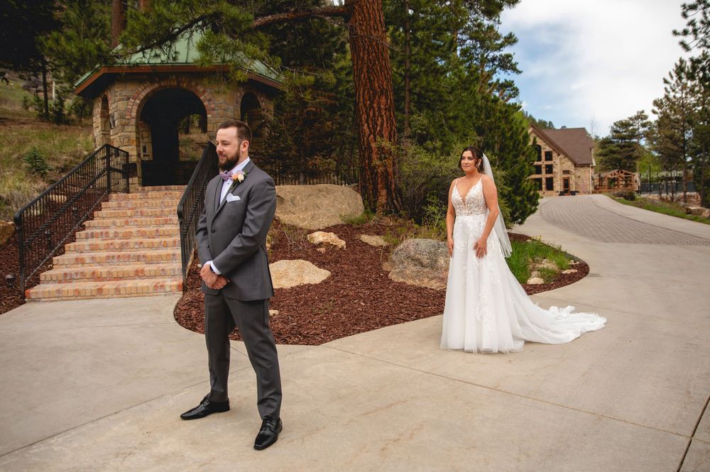 Soon-to-be newlyweds share a first look moment on a winding path near stone stairs at an outdoor wedding venue.