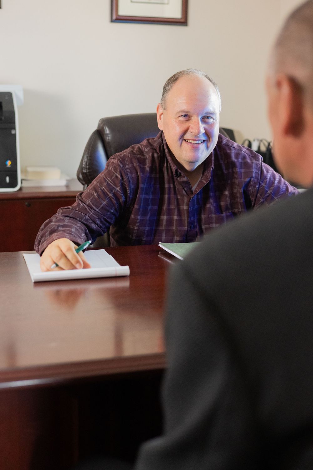 Business meeting in progress showing two people discussing documents at a conference table.