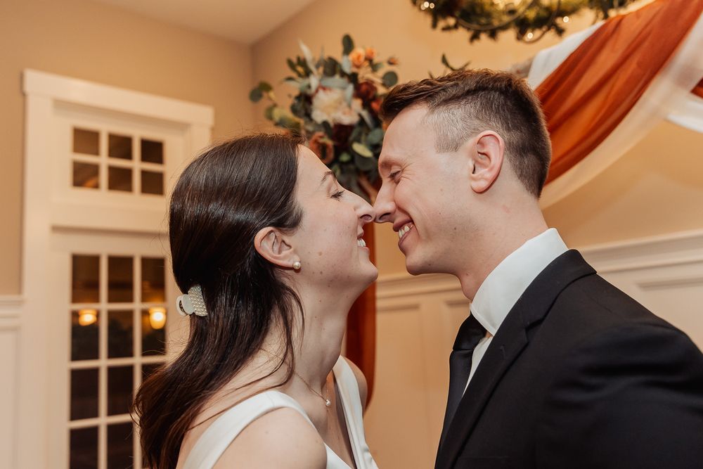 A couple shares a tender moment together during their wedding celebration in a warm indoor setting.