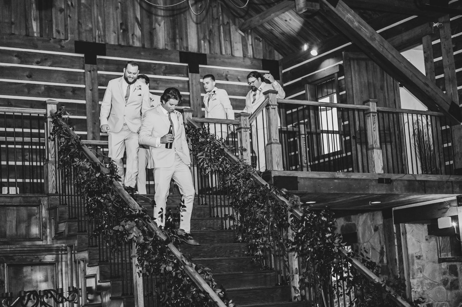 dapper groomsmen walk down the stairs at the lodge at the springs to enter the reception for their grand entrance