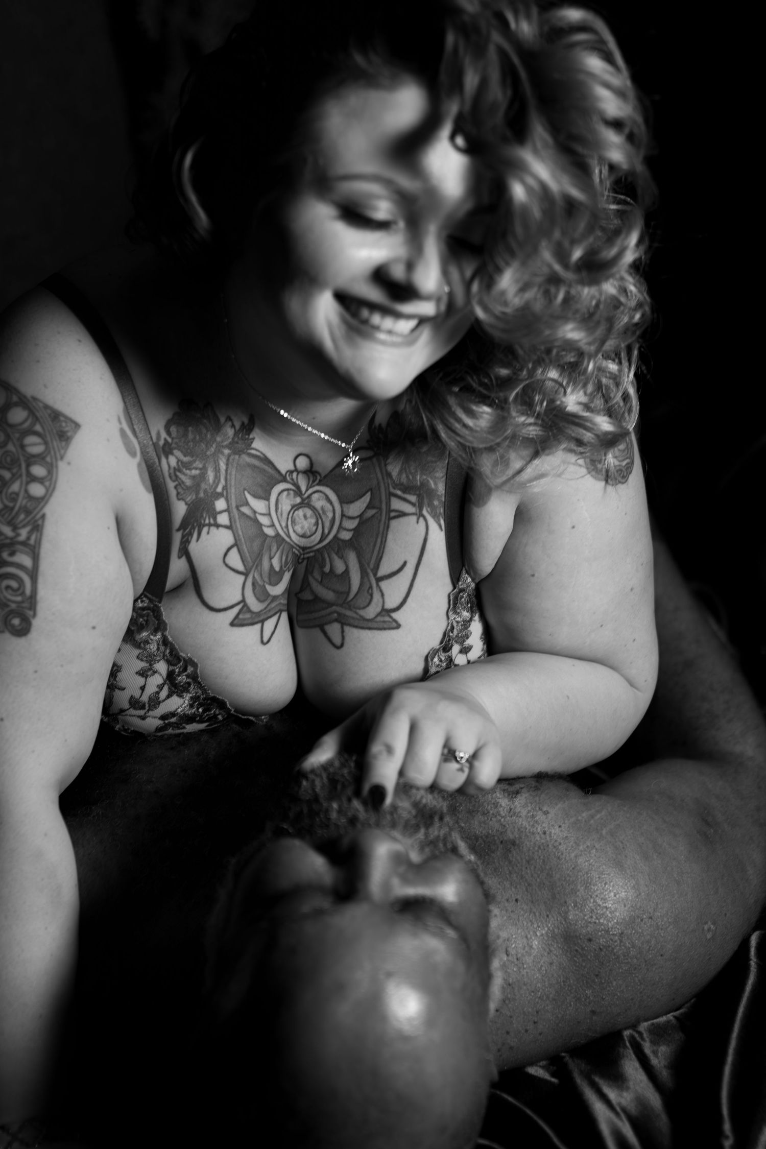 A couple enjoys an authentic playful and flirty moment of connection during a transformative boudoir session with Lock and Key Photography.