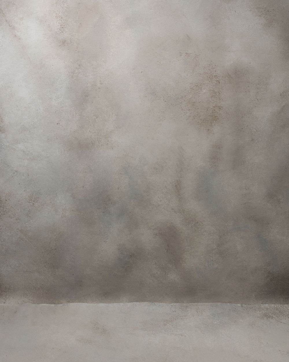 A textured gray studio backdrop with gradient lighting creates a moody atmospheric effect.