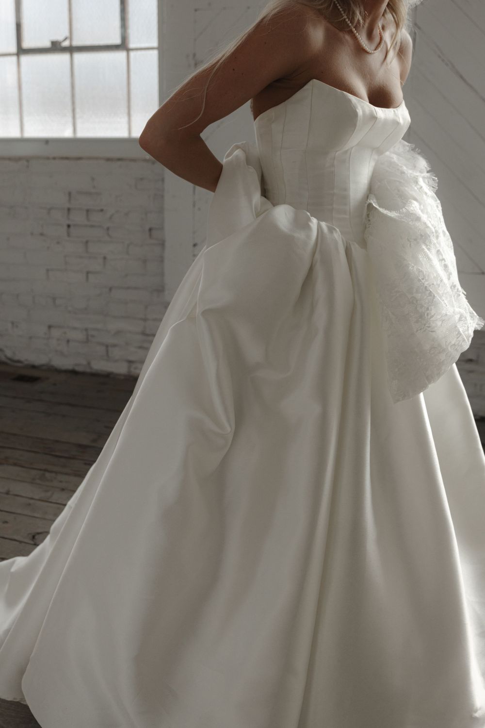 Close-up of elegant white wedding dress with strapless bodice and full skirt details.