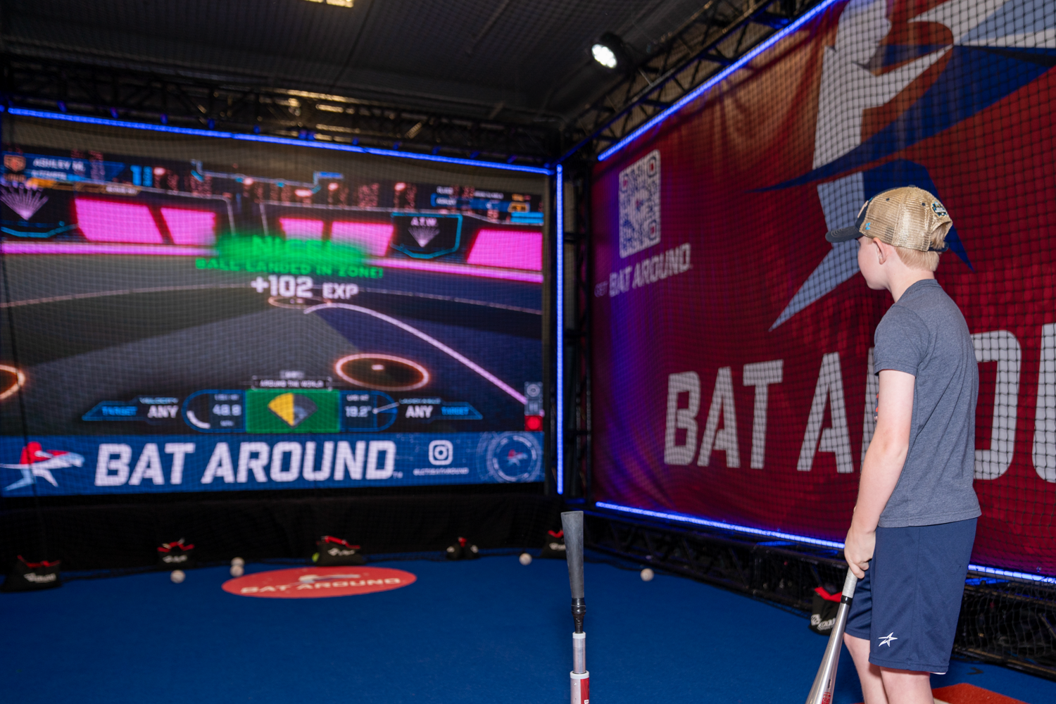 Gaming setup showing virtual batting practice on large display screens.