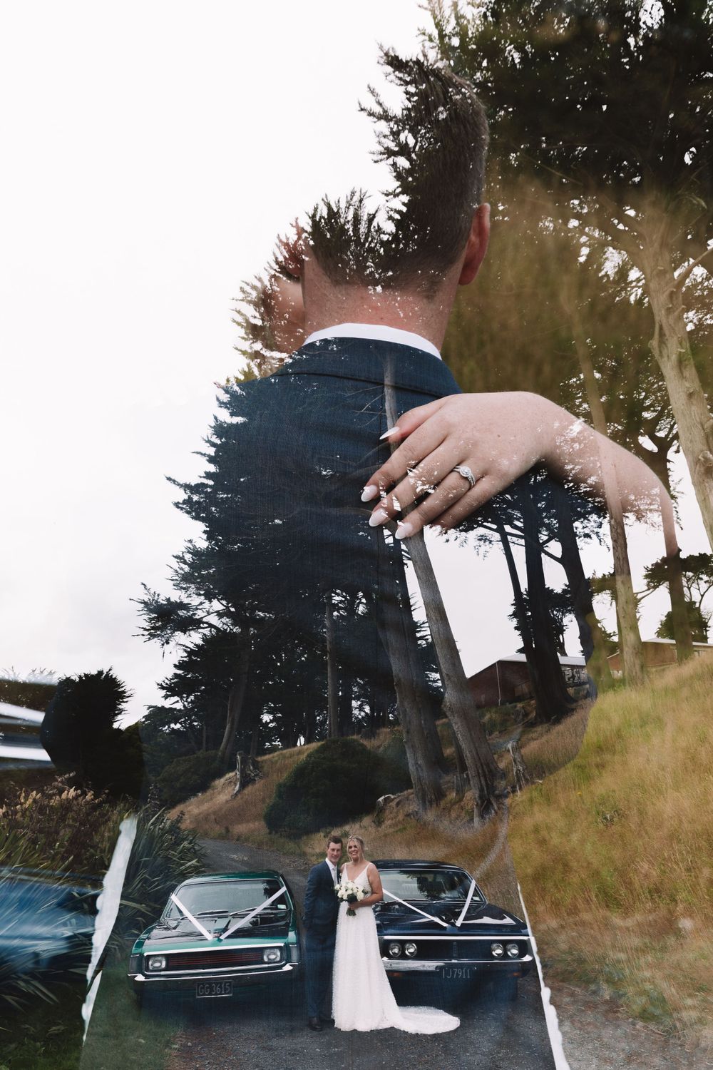 Double exposure wedding photo showing classic cars and tall pine trees on a hillside.