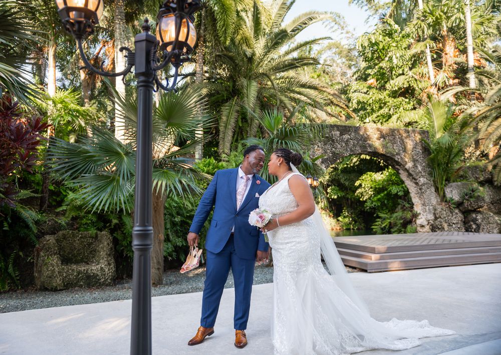 Bride’s gown flowing across stone pathways in the gardens, captured by Miami wedding photographers.